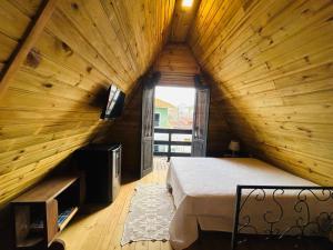 ゴヴェルナドール・セウソ・ラーモスにあるPraia de Palmas - Chaléの木製の屋根裏部屋のベッド1台が備わる広い客室です。