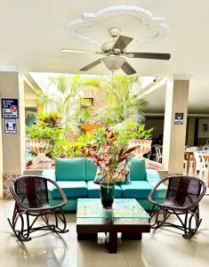 a living room with a blue couch and two chairs at Olas del Mar by GHO Hoteles in Santa Marta