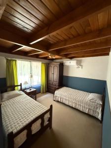 two beds in a bedroom with green curtains at Quinta en Pilar - cerca del Polo in Pilar
