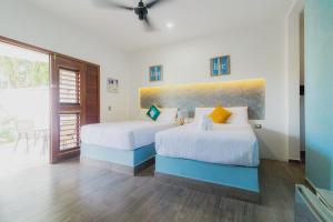 een slaapkamer met twee bedden en een schilderij aan de muur bij Hotel Maria Maria in Bacalar +54 foto's