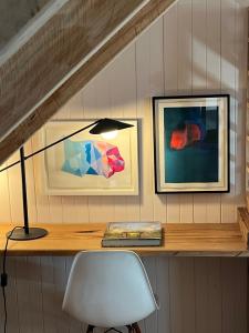 una scrivania con una lampada e due quadri su una parete di The Barn at Stonewalls - Farm stay in 25 acres a Musk