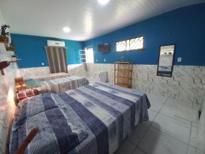 a bedroom with two beds and blue walls at Pousada Sítio Boas Novas in Caucaia