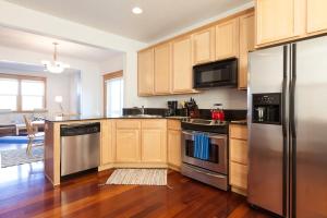 Una cocina con gabinetes de madera y electrodomésticos de acero inoxidable. en Private Reserve townhouse, en Hood River