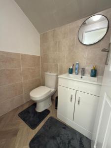 a bathroom with a toilet and a sink and a mirror at Axion property in Swindon