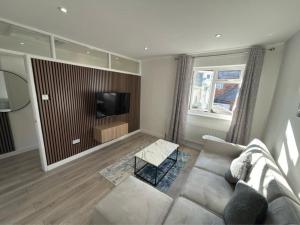 a living room with a couch and a tv at Axion property in Swindon