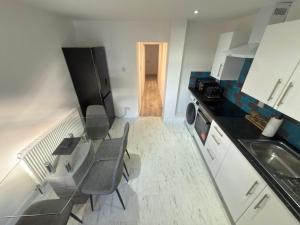 a kitchen with a table and chairs and a black refrigerator at Axion property in Swindon +2 photos