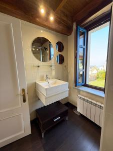 een badkamer met een wastafel, een spiegel en een raam bij Casa Chita in Tapia de Casariego