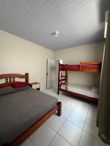 a bedroom with a bed and two bunk beds at Casa Jardins in Barreirinhas