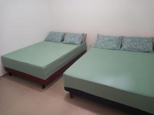 Dos camas una al lado de la otra en una habitación. en Casa para temporada Amargosa-ba, en Amargosa