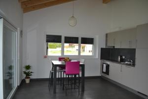 朗斯的住宿－Appartement Lens，厨房配有桌子和粉红色的椅子