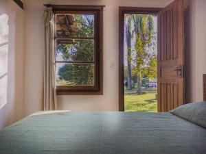 a bedroom with a bed and an open window at Camping Tiradentes in Tiradentes