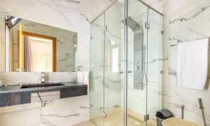 Oulad AkkouにあるDar Zwinaのガラスのシャワーと洗面台を備えたバスルーム