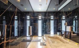 Oulad AkkouにあるDar Zwinaの黒い壁と鏡付きの浴槽のあるバスルーム