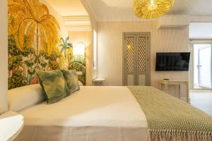 a bedroom with a large bed and a painting on the wall at La Casa de la Plaza del Arroyo - Traditional Luxury in Jerez in Jerez de la Frontera