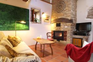 un soggiorno con divano e camino di Casa Raiz Guest House & Retiro a Ferreira do Zêzere