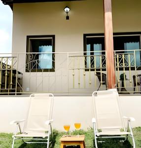 2 sedie e un tavolo sul balcone di Chalé Citrino Conforto vista para Montanhas - no melhor da Lapinha da Serra a Santana do Riacho