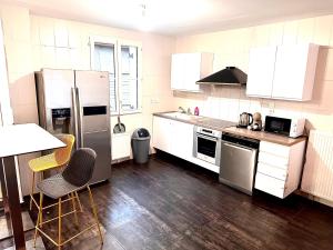 a kitchen with stainless steel appliances and wooden floors at réf rog Chambre Privée dans une villa partagée in Magny-le-Hongre