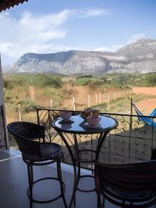 un tavolo con sedie e vista sulle montagne di Chalé Topázio Azul Natureza plena sossego Lapinha - no melhor da Lapinha da Serra a Santana do Riacho