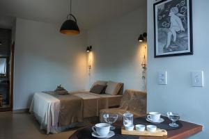 Cette chambre comprend un lit et une table avec des tasses. dans l'établissement Chale Esmeralda Conforto Lago Natural Sossego - no melhor da Lapinha da Serra, à Santana do Riacho
