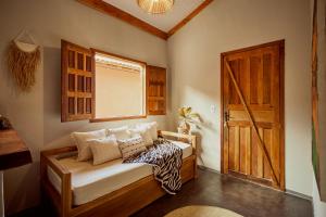 a room with a bed and a wooden door at Vila Três - A apenas 2 minutos da praia! in Caraíva