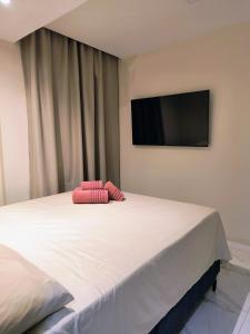 a bed with two red pillows on top of it at Espaço Zen in Camaçari