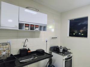 a small kitchen with a stove and a sink at Espaço Zen in Camaçari +3 photos