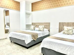 サンタ・マルタにあるSANTO RIO BOUTIQUE Hotelのベッド2台と鏡のある寝室