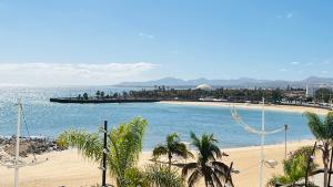 a view of a beach with a boat in the water at Balcón del Mar in Arrecife