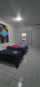 a room with two beds and a painting on the wall at Pousada Familiar 10 in Rio do Sul