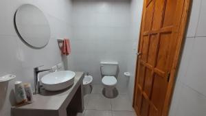 a bathroom with a toilet and a sink and a mirror at Sol de Abril in Russell