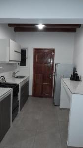 a kitchen with white counters and a brown door at Sol de Abril in Russell