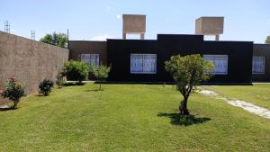 a black building with a tree in a yard at Sol de Abril in Russell