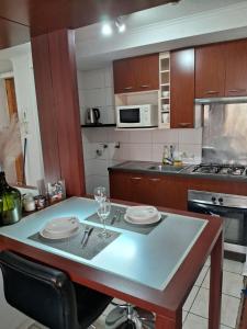 a kitchen with a table with plates and glasses on it at Loft Rousse Travel in Santiago