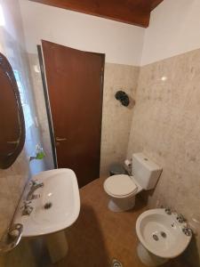 ein Badezimmer mit einer weißen Toilette und einem Waschbecken in der Unterkunft Casa en las Sierras de Cordoba in Villa Parque Siquiman