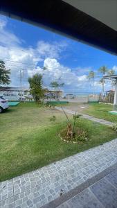 a dog sitting on the grass in a yard at Pousada Predileta in Itaparica