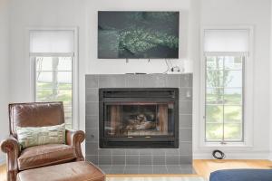 a living room with a fireplace with a tv above it at The Victory Lounge - 3B 3BA - Close to ND in South Bend
