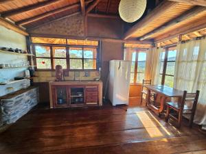 a kitchen with a refrigerator and a table in it at Chalés Vila Carrancas - Unidade Serra in Carrancas
