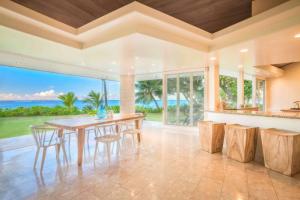 an open kitchen and dining room with a table and chairs at Utopia Beach Front Estate in Kilauea