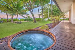 a wooden deck with a hot tub in the middle of a yard at Utopia Beach Front Estate in Kilauea