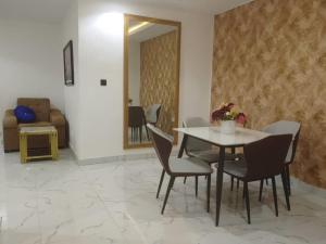 a dining room with a table and chairs and a mirror at Aquarian Spring Homes in Ikeja +5 photos