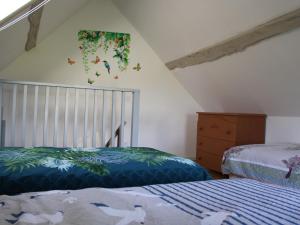 ein Schlafzimmer mit 2 Betten und einem Kinderbett in der Unterkunft Charme champêtre entre Le Mans et Tours, maison rénovée en pleine nature - FR-1-410-480 in Flée