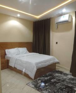 a bedroom with a bed and a air conditioner at Aquarian Spring Homes in Ikeja