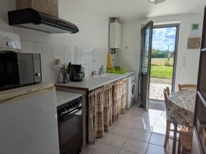 una cucina con un lavello e un piano di lavoro di Gîte cosy en Val de Loire, proche Loire, Sologne, Sully/Loire - 1 ch, salon, cuisine, linge inclus - FR-1-590-30 a Guilly