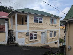 a small house with a green roof at BTC Apartments in Saint Georgeʼs