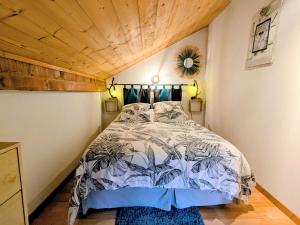 a bedroom with a large bed with a wooden ceiling at Charmant meublé au calme, proche cascades, randos, chevaux, parking et terrasse privée, WiFi gratuit - FR-1-589-365 in Le Tholy