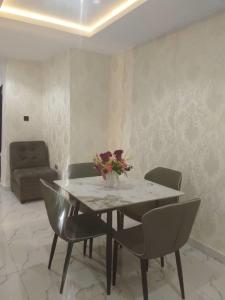 a dining room table with chairs and a vase of flowers at Aquarian Spring Homes in Ikeja
