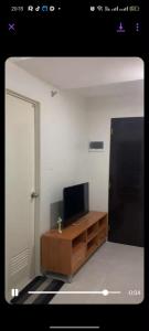 a living room with a television and a wooden desk at Deca Homes Condo Banilad Cebu in Mandaue City +1 photo