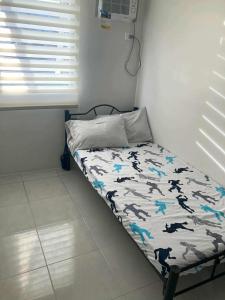 a small bed in a room with a bedskirtspectspectssenalsenalsenalsenal at Deca Homes Condo Banilad Cebu in Mandaue City