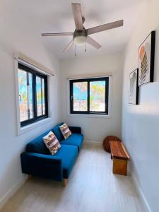 a living room with a blue couch and a ceiling fan at Curacion Beach Resort in Brick Bay