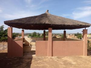 a large straw umbrella on top of a building at La Villa sûr in Niamey